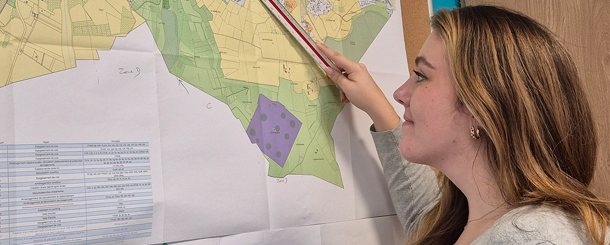 Agent en charge de l'urbanisme en train de regarder une carte du PLU de Saint-Quentin-Fallavier